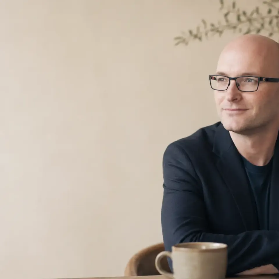 Andrew Bull, founder of Guidra, sitting at a desk with coffee