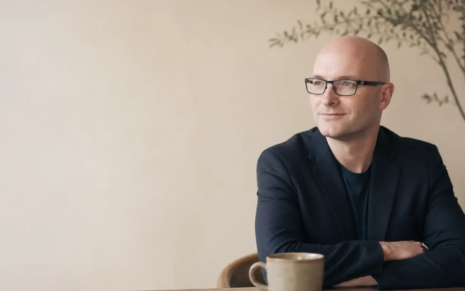 Andrew Bull, founder of Guidra, sitting at a desk with coffee